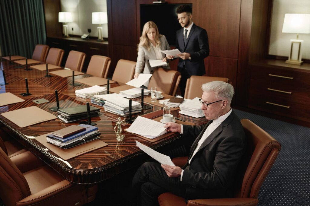 Lawyers Looking Through Piles of Documents During Workday in Boardroom