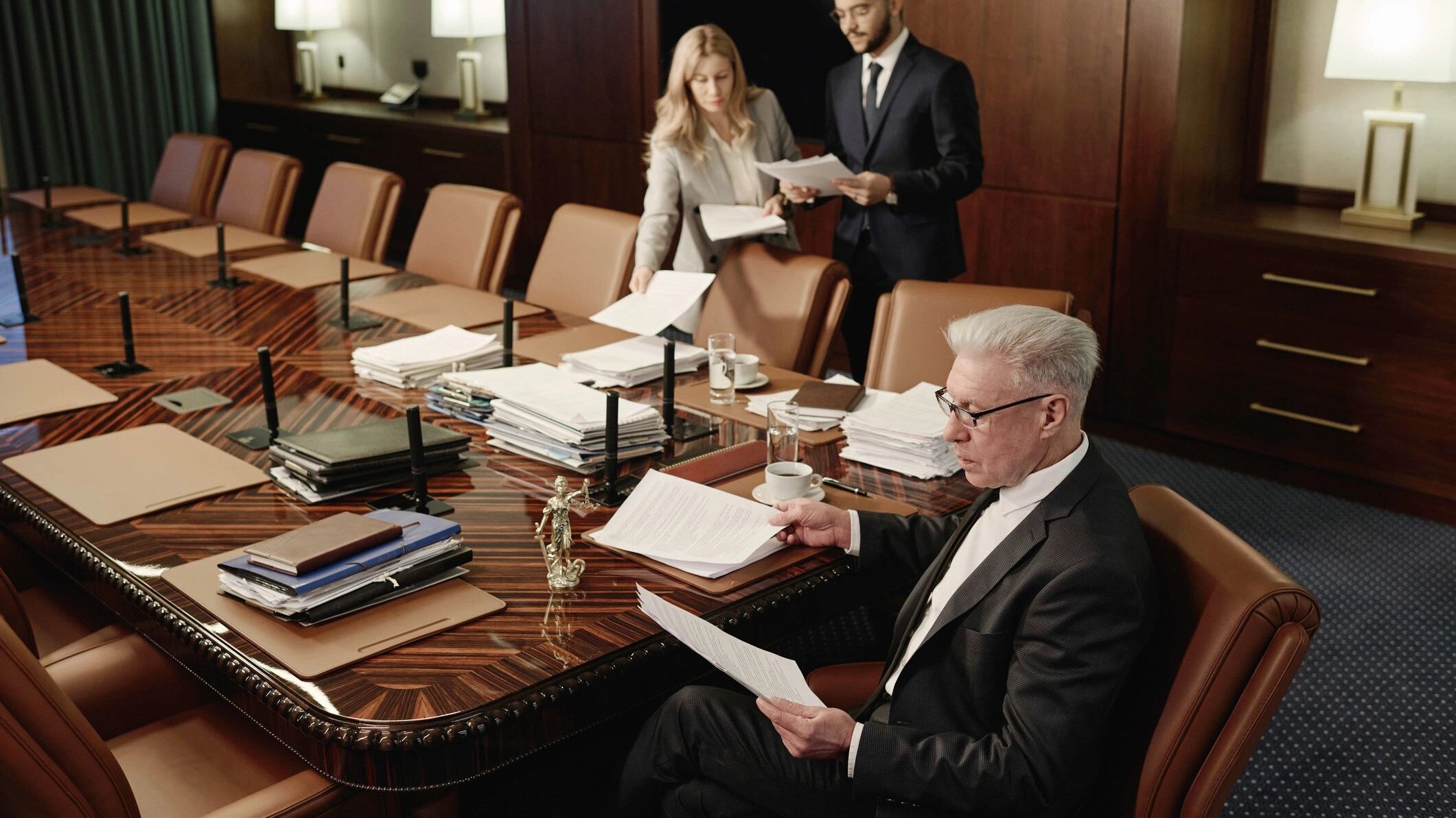 Lawyers Looking Through Piles of Documents During Workday in Boardroom